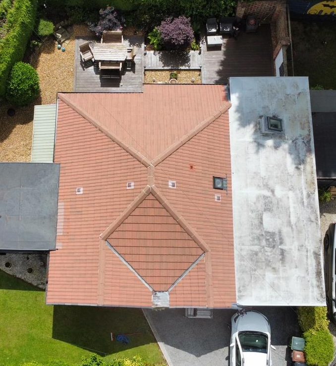 a house with a roof and a car parked in the driveway